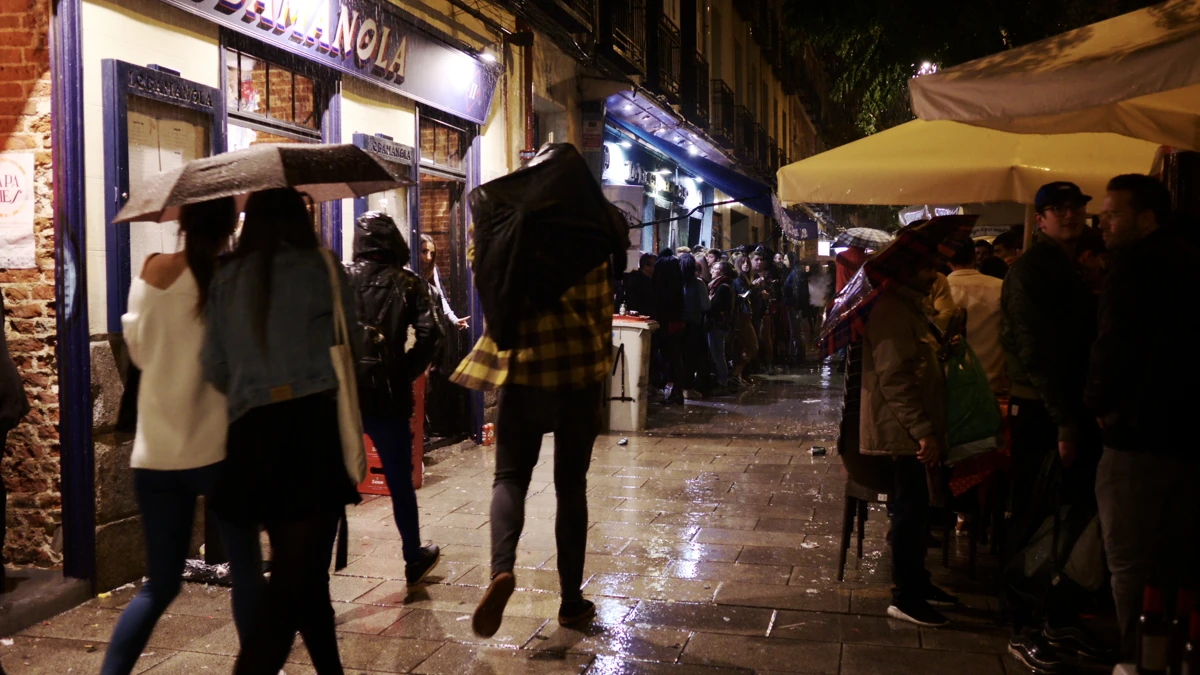 Peatones con paraguas en una calle de Madrid, imagen ilustrativa de lluvia ajena a la DANA Adam